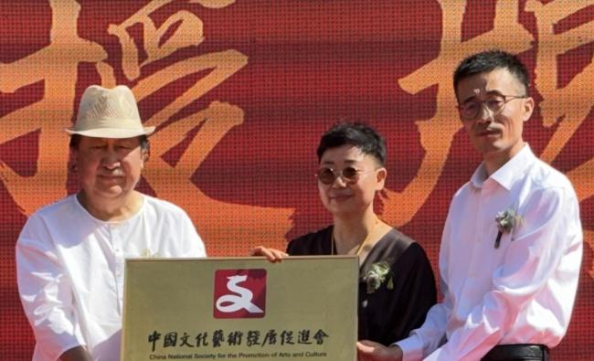 中国文化艺术发展促进会主席、国度画院原院长杨晓阳为白小菊、任平授牌“中国文化艺术发展促进会鹿野苑文化职责委员会”钱晓鸣照相